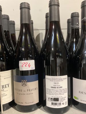 plusieurs bouteilles de vin sont alignées sur une étagère