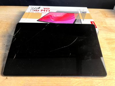un ordinateur portable noir posé sur une table, sur laquelle se trouve une boîte