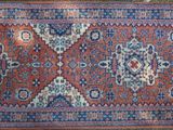 a close up of a rug on the ground with a wooden floor in the background