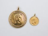 une pièce d'or et un pendentif en or sur fond blanc