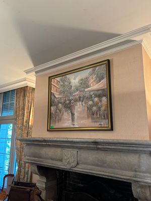 un tableau accroché au mur au-dessus de la cheminée dans un salon