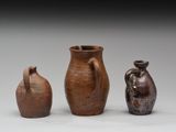 trois vases marron posés les uns à côté des autres sur une surface blanche