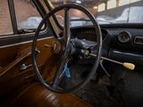 steering wheel and dashboard of an old car in a parking lot