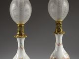 pair of white and gold vases with floral designs on them