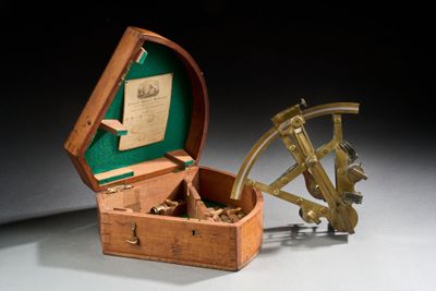 une petite boîte en bois contenant un sexet en laiton
