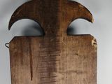 an old wooden cutting board with a wooden fleur on it