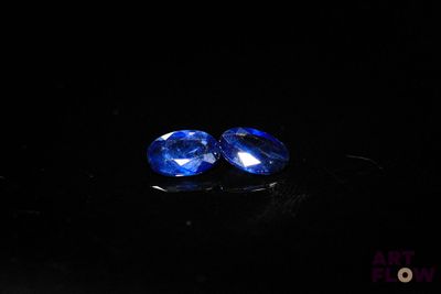 a pair of blue sapphires on a black surface