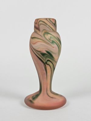 un vase rose orné d'un motif vert et blanc