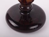 a brown glass vase with a flower on top of it