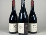 trois bouteilles de vin rouge sont alignées sur une surface blanche