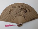 a fan that has a design on it with a pink tassel