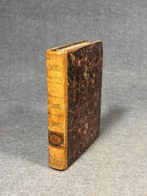 an old book sitting on top of a table next to a gray surface