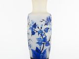 un vase blanc orné de fleurs bleues sur fond blanc