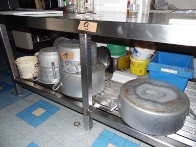 many pots and pans on the shelf in the kitchen