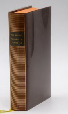 an old book sitting on top of a white table next to a yellow ribbon
