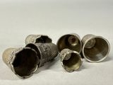 three silver thimbles sitting on top of a table next to each other