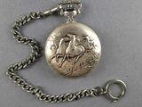 an antique silver pocket watch with a chain on a gray surface