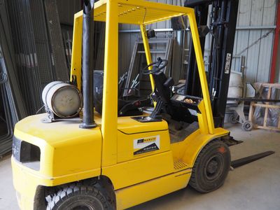 un chariot élévateur jaune garé dans un entrepôt