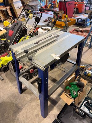 une table sur laquelle est posée une scie, dans un atelier