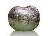 un vase en forme de pomme orné d'un motif représentant des arbres