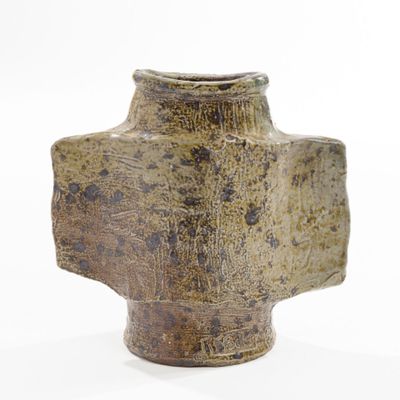 a brown vase sitting on a white surface with a white background