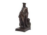 statue en bronze représentant un homme assis sur un rocher avec un chien