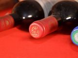 several bottles of wine are lined up on a red table