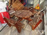 a wooden table and four chairs in the sand