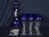 six verres à vin et une carafe posés sur une table