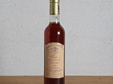 an empty bottle of wine sitting on top of a wooden table