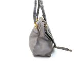grey leather handbag on a white background with a gold handle