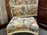 a chair with a floral upholstered seat next to a chest of drawers