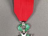 la médaille est accrochée à un ruban rouge orné d'une étoile