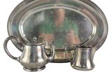 a silver plate with a silver tea pot and a silver plate with a silver tea pot