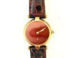 un gros plan d'une montre-bracelet au cadran rouge
