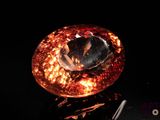 a close up of a large orange diamond on a black surface