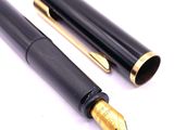 a black pen with a gold tip and a black pen with a gold tip