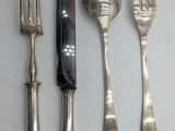 four forks, a knife, and a spoon on a table