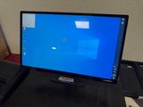 a computer monitor sitting on a desk with a laptop next to it