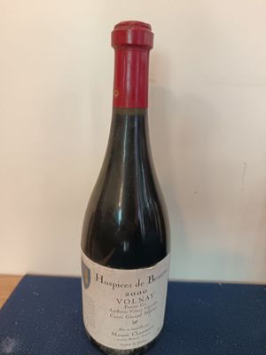 a bottle of wine sitting on a blue table
