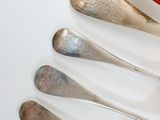 five spoons that are sitting next to each other on a table