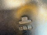 an antique silver plate with a small metal tag on it