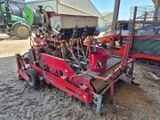 une machine rouge qui est à l'arrêt dans la poussière