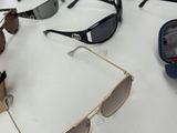 many pairs of sunglasses sitting on a table next to a cell phone