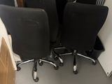 three black office chairs sitting in a room with cardboard boxes on the floor