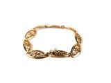 an image of a close up of a gold bracelet on a white background
