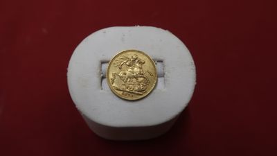 une pièce d'or posée sur une boîte blanche