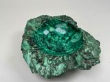 un gros plan d'un bol vert posé sur une surface blanche
