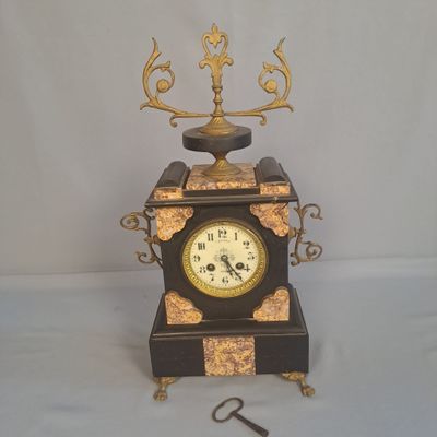 une horloge posée sur une table, avec une clé