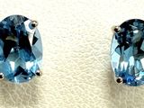 two pairs of blue topaze earrings on a white surface